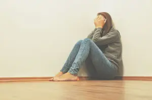 47015498 - sad girl hiding in corner at home